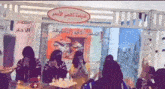 a group of women are sitting at a table with a sign that says ' a ' on it .