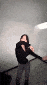 a blurry picture of a woman in a black shirt and jeans dancing