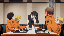 a group of anime characters are sitting around a table with the number 2 on the back of their jackets