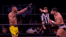 two men are wrestling in a ring while a referee looks on .