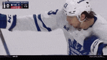 a hockey player with the number 23 on his helmet stands on the ice