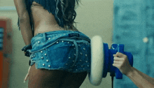 a woman in denim shorts is being polished by a person