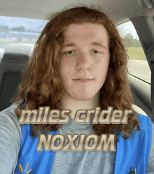a man with long red hair is wearing a walmart vest and the name miles crider is on the bottom
