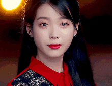 a close up of a woman 's face wearing a red shirt and red lipstick