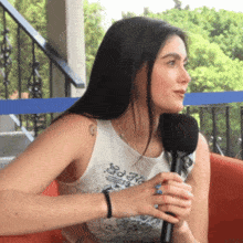 a woman is holding a microphone and wearing a shirt that says ed nc on it
