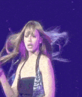 a woman with her hair blowing in the wind is on a stage