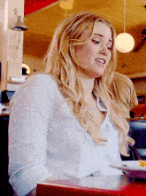 a woman sitting at a table with a plate of food