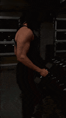 a man is lifting a dumbbell in a gym