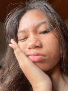 a woman with her hand on her face making a face
