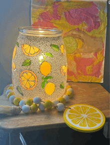 a candle holder with lemons painted on it sits on a table