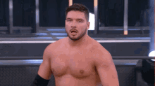 a shirtless wrestler with a beard stands in a ring