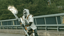a man in a white and gold costume holds a torch
