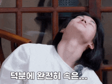 a woman laying on a chair with her eyes closed and korean writing on the bottom