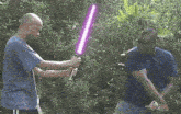 two men are fighting with purple lightsabers in a forest
