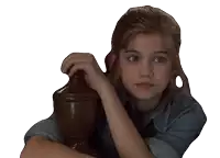 a young girl in a denim shirt leans on a wooden pillar