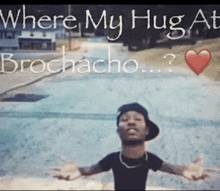 a man with his arms outstretched in front of a sign that says where my hug at brochecho ?