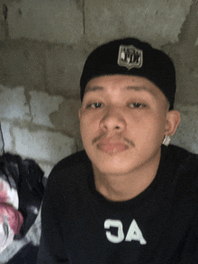 a young man wearing a black hat and a black shirt that says 3a