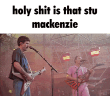 a man singing into a microphone while another man plays a guitar with the caption holy shit is that stu mackenzie