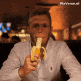 a man in a white shirt is eating a banana with pixverse.ai written in the corner