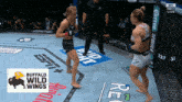 two women are fighting in a boxing ring with a buffalo wild wings logo in the corner