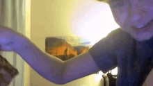 a man 's arm is visible in front of a painting of a mountain
