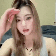 a woman with long blonde hair is holding her hair in her hand .