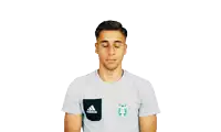 a man wearing a grey adidas t-shirt is making a face