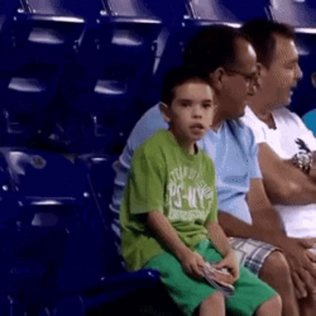 reaction gif of a little boy busting out a funny celebratory dance in the stands of (probably) an unknown sports event