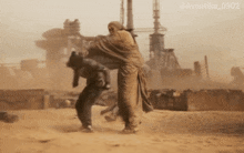 a photo of a man carrying another man in the sand has the hashtag avantika_0902 at the bottom