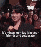 a man is standing in front of a crowd with a sign that says it 's minus monday join your friends and celebrate