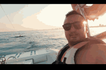 a man on a boat wearing sunglasses and a life vest