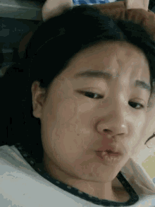 a young girl making a funny face with her mouth closed