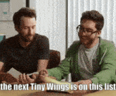 two men are sitting at a table with the next tiny wings on this list