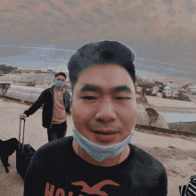 a man wearing a hollister shirt and a face mask