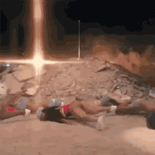 a group of people are laying on the ground with a light coming out of the ground