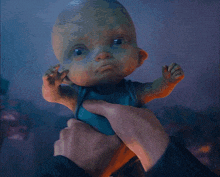 a person is holding a crying baby doll