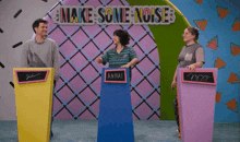 a group of people standing in front of a sign that says make some noise