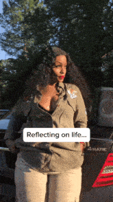a woman is reflecting on life in front of a mercedes car