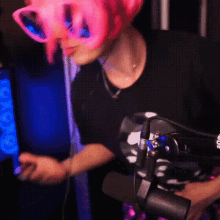 a woman wearing a pink wig and sunglasses is holding a microphone
