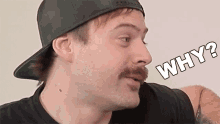 a man with a mustache is wearing a black hat and asking why