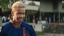 a man in a superhero costume is standing in front of a building holding a book .