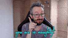 a man with glasses and a beard is pointing up with the words you are so naughty below him