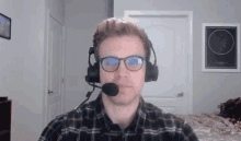 a man wearing glasses and a headset is looking at the camera