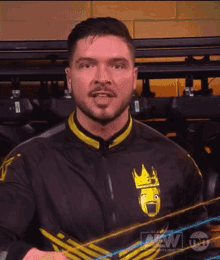 a man wearing a black and yellow jacket with a crown on the front