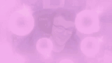 a man wearing headphones and glasses is sitting in a gaming chair with pink bubbles coming out of his head .