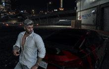 a man standing next to a red car with a license plate that says 52182