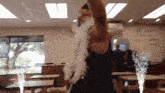 a man in a black tank top is standing in a restaurant with tables