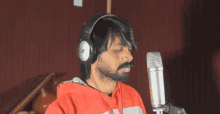 a man singing into a microphone with a pair of headphones that say ' z ' on them