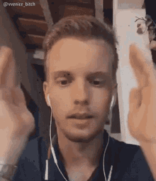 a man wearing headphones is making a funny face and giving the middle finger .