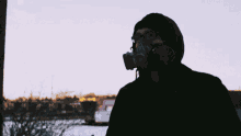 a man wearing a gas mask holds up a pink spray can with the word zoo on it